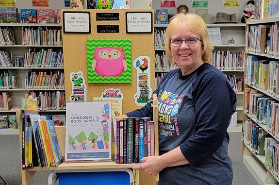 Terri Horacek displays some of the books already collected for the Plainfield Library Book Drive.