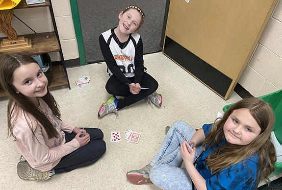 Third Graders Emmersyn Nowak, Emmersyn Pietkauskis, and Kendra O’Kon play cards in Mrs. Michalski’s class during Game Day at Riverview Elementary School.