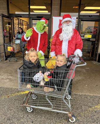 Sisters Piper and Tallulah were surprised to have a visit from the Grinch and Santa before their grocery shopping trip.