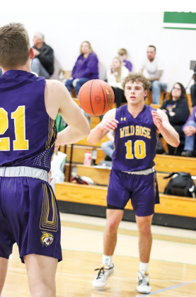 Wildcat Wyatt Bowen sends a pass off to senior Evan Tratz as the clock wound down in the second half of Regional action at Almond-Bancroft High School on March 1.