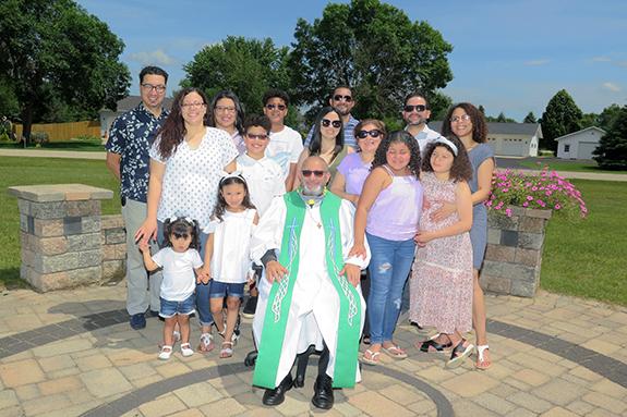 Pastor Rafael Cubilette posed for a picture with his family members who attended his farewell picnic at Grace United Methodist Church in Wautoma on June 28:  (back row) son-in-law Oscar Diaz, daughter Irina Diaz, grandson Gabriel Diaz, 14, brother Rafael Cubilette, son-in-law Luis Tavarez, daughter Clara Tavarez, (center row) daughter Claudia Verhagen, grandson Daniel Diaz, 10, family friends Ceranny Pujols and Olga Tavarez, (front row) granddaughters Mila Verhagen, 2, and Maya, 6, Pastor Cubilette, and gra