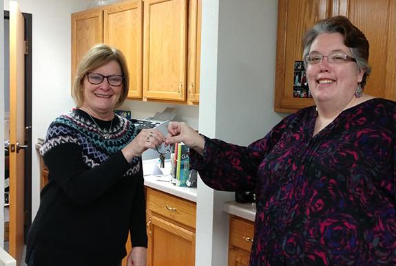 Linda Helmrick, former Plainfield Library Director, hands over the keys to the new director Deb Sadowski. Deb is the new Plainfield Library Director and looks forward to her time in the community.