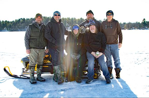 Chad Zuehlke, Coloma, Todd Pavolski, Oregon, Sean Crowley, Coloma, Bryan Swiontek Kellner, Adam Helminak, Deerfield, AJ Koch, Stevens Point, and Bennie the dog take a break from fishing to tell their fish stories to each other at the Coloma Lions Fisheree at Pleasant lake. On Feb. 12th