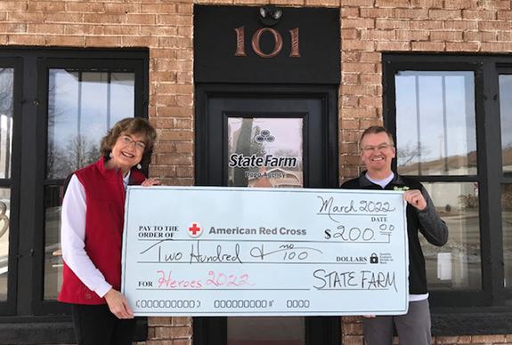 Vicki P. Jenks is presented a check from Joey Dopp for the 2022 American Red Cross HEROES program.