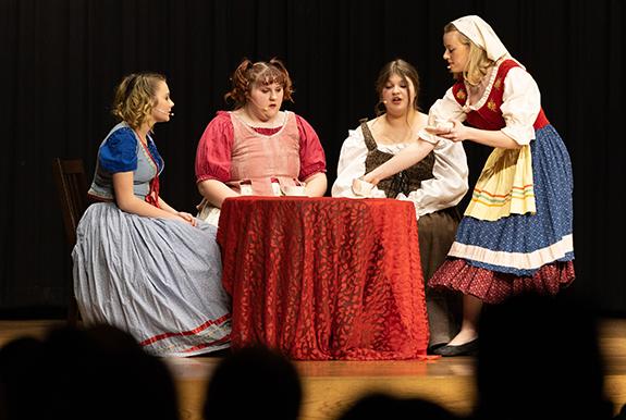 Cinderella played by Ella Winn serves her stepmother (Adrianna Conley) and stepsisters (Vivian Kramer and Isabella Behnke) tea.   