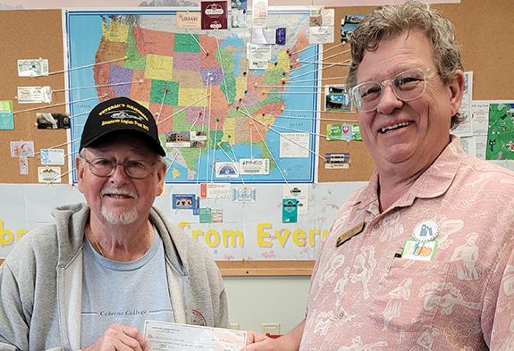 Patrick Holland of Wild Rose American Legion Daniel Dopp Post 370 presents a $200 check to Kent Barnard, Patterson Memorial Library Director, to help pay for the library’s new Community Calendar. 