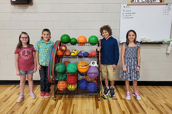 Wild Rose Elementary students Haylee Roemer, Eastyn Boersma, Slayden Viau, and Scarlett Johnston are pictured with some of the equipment purchased by the volunteers.