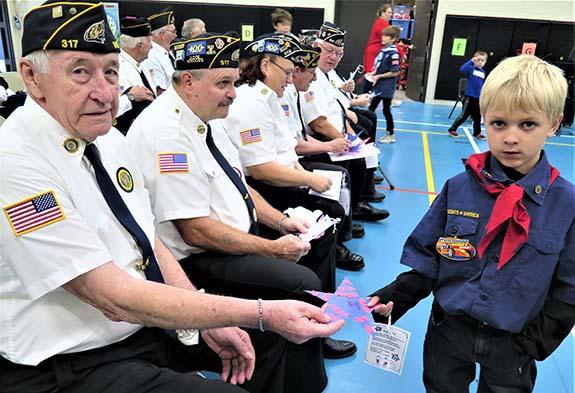 Riverview Elementary School student Eli Nigel presented a handmade gift of a star to American Legion Post 317 member Thomas Hardy during the Veterans Day Program. Other American Legion Post 317 members pictured are:  Tom Raymond, Jane Giampoalo, Marty Czarnecki, Jr., and Legion President Kevin Miller.