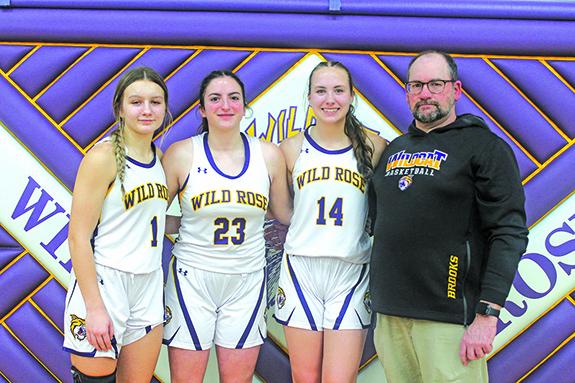 Seniors Laney Havlovitz, Mati Bigotti (Italy), and Gracie Thompson were honored at the Feb. 14 girls’ basketball game against Princeton/Green Lake. Pictured with the girls is Wild Rose Head Coach Brett Brooks. 