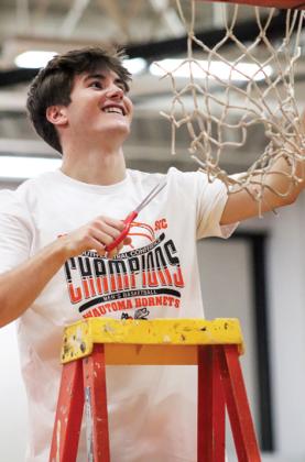Following the game, the Hornets cut the winning game net. Logan Dunn cuts his piece of the net. 