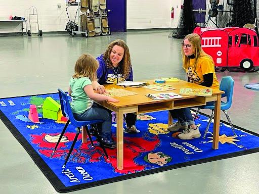 Erin Martinson- 4K Teacher, and Jessica Bahr - Student Intern, spend time with one of the Child Development Day participants. 