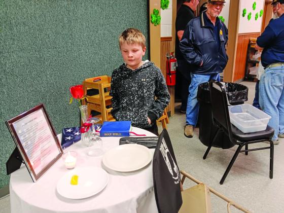 Zander Johnson, in 3rd grade at Coloma Elementary School, inspects the POW/MIA Missing Man honor table at the event to remember those fellow warriors that have not been forgotten.